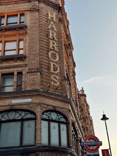 A busy city street scene in Knightsbridge featuring historic historic buildings with ornate architectural details and large windows. The street is filled with various vehicles, including a red and whi